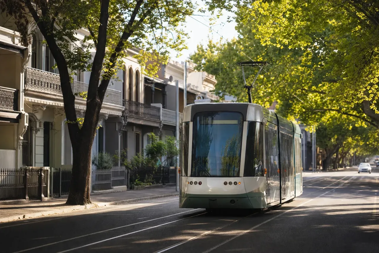 A Melbourne tram on a leafy inner-city street lined with terrace houses